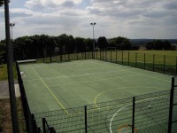 Rebound fencing, polymeric surfacing and floodlights for a multi use games area